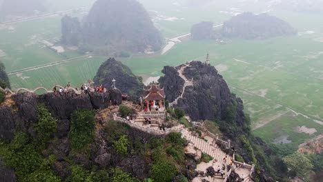 Aerial-from-the-top-of-Vietnamese-dragon-temple-on-top-of-large-limestone-karst