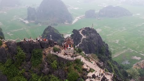 Aerial from the top of Vietnamese dragon temple on top of large limestone karst