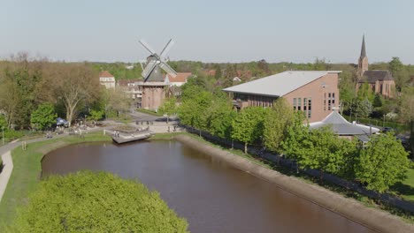 citypark in north germany with windmill and curch in papenburg at a beautiful spring day