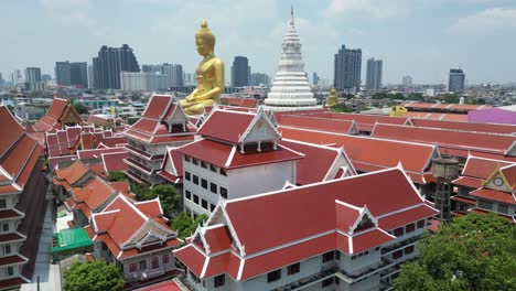 buddha statue and temple with a city skyline in the background in bangkok, thailand