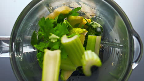 raw green vegetable falling blender in super slow motion close up. vitamin food.