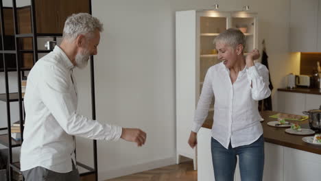 feliz casal sênior se divertindo e dançando em casa