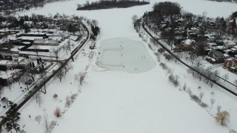 people playing ice hockey on frozen pond in winter