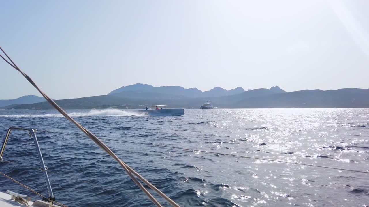 Handheld shot of a luxury and modern dinghy  of the SY A with the Super Yacht A in the background.