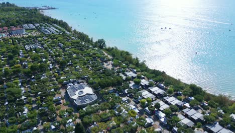 Antena-Panorámica-De-La-Luz-Del-Sol-Brillando-En-El-Hermoso-Lago-De-Garda-Italia-Casas