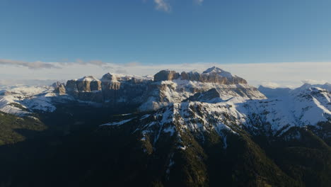 imágenes aéreas volando hacia los picos de las montañas de colac por la ciudad de canazei en los dolomitas.