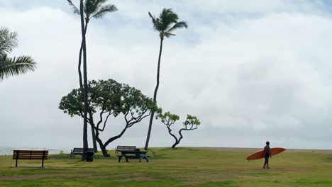 Man-walking-with-surfboard-near-beach-4k