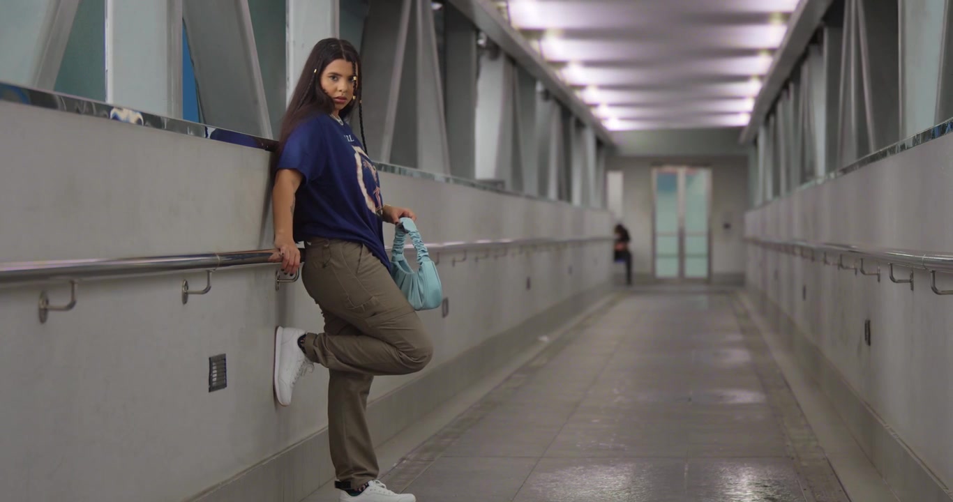 A Port of Spain, Trinidad, una giovane donna latina in abbigliamento streetwear alla moda si gode una passeggiata panoramica