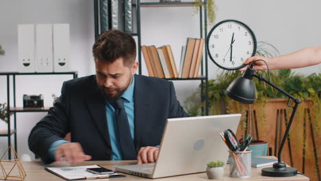 young businessman with anxiety checking time on clock running late to work being in delay deadline