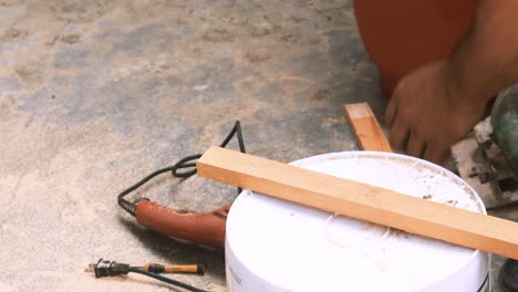 close up view of carpenter performing skillfully a cut into a piece of wood with his industrial circular saw machine which he uses often in his small business elaborating professional forniture