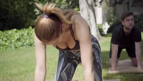 joven y mujer practicando yoga al aire libre