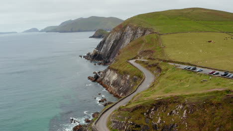 Aerial-footage-of-car-park-and-people-at-tourist-attraction-on-sea-coast.-Picturesque-landscape-scenery.-Ireland