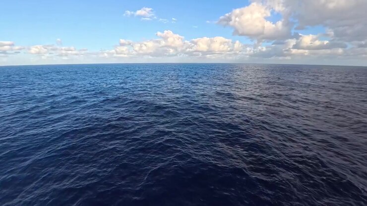 Ampia superficie dell'oceano blu sotto un cielo luminoso