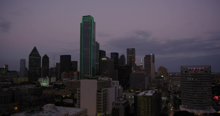 Il giorno sfuma nella notte in questa clip in timelapse dello skyline del centro di Dallas al tramonto. In questa clip vediamo nuvole muoversi sopra gli edifici e auto sfrecciare velocemente per le strade sottostanti.