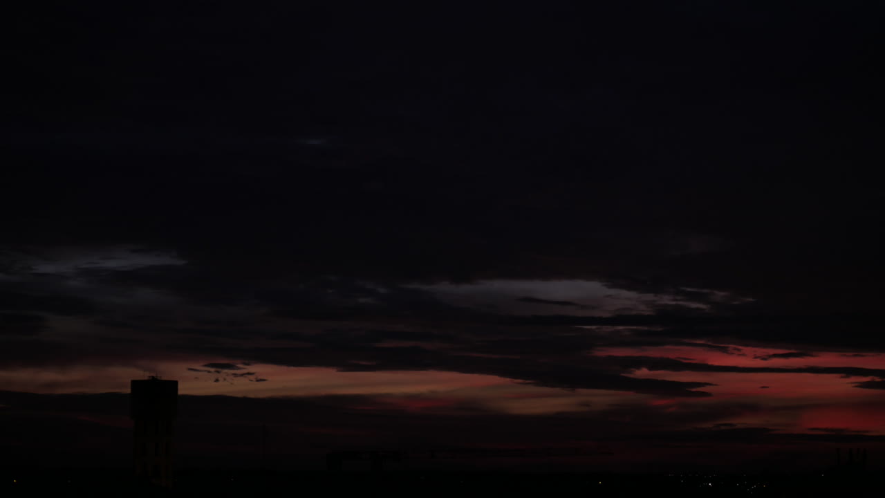 nubes moviéndose sobre la ciudad desde el atardecer hasta la noche.