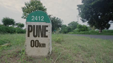 highway milestone showing distance of pune