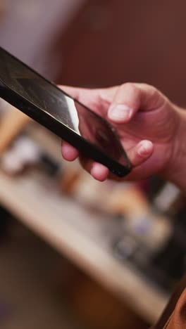person takes photo of simple men black leather wallet with cellphone in studio closeup. master of manual manufacture shows product online