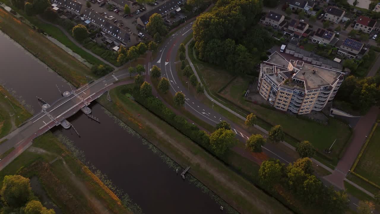 Aerial View of a Residential Area with Canal and Road at Golden Hour