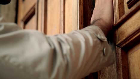 man knocks traditional wooden door