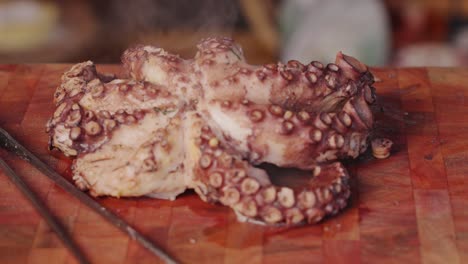 Close-up-dolly-in-and-out-shot-of-a-cooked-eight-legged-molluscs-octopus-with-hot-steam-visibly-appearing-from-freshly-cooked-octopus