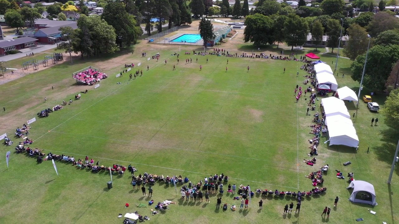 Bredt luftfoto af hele banen med touch rugby og tilskuere.
