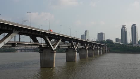 首爾地鐵列車經過<unk>大橋, 景色如畫的城市天際線和高塔在日落