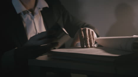 pale bald accountant looks through the tax papers in the weird room at night