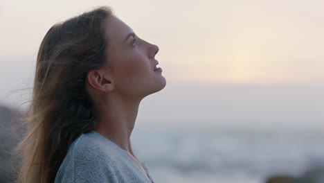 portrait of beautiful woman enjoying calm seaside at sunset exploring spirituality looking up praying contemplating journey relaxing on beach