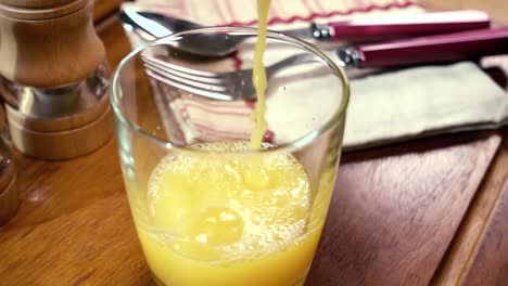 orange juice pouring into a glass, the morning breakfast. slow motion with rotation tracking shot.