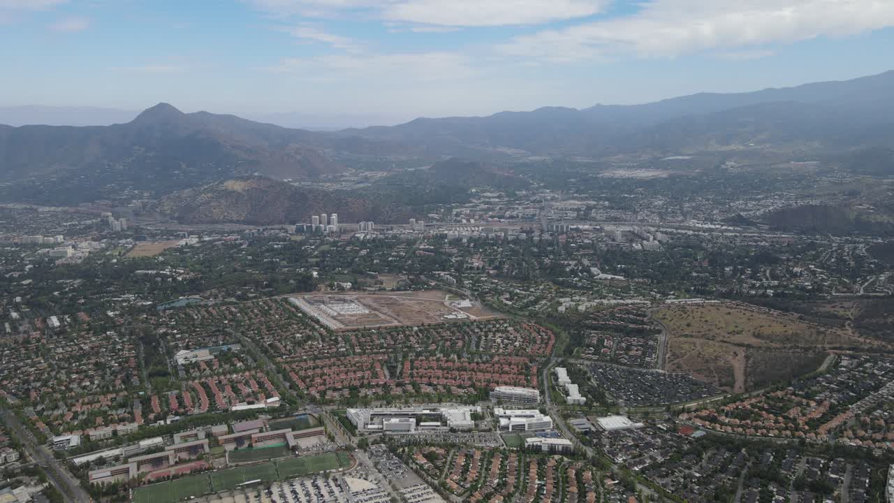 Urban santiago cityscape with cerro san cristobal hill showing stadium, buildings and mountains in the background