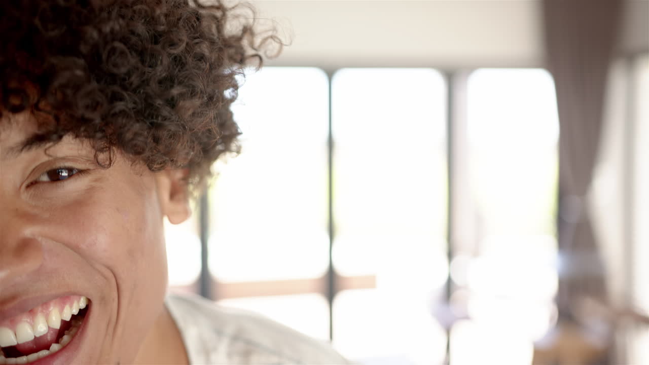 A young biracial man with a bright smile is featured with copy space at home