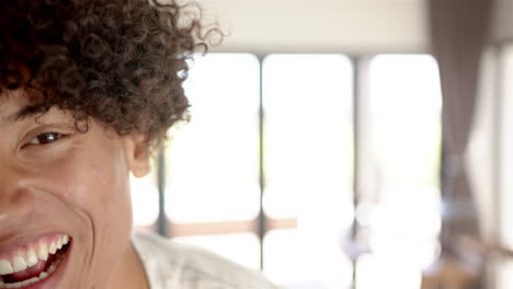 A-young-biracial-man-with-a-bright-smile-is-featured-with-copy-space-at-home