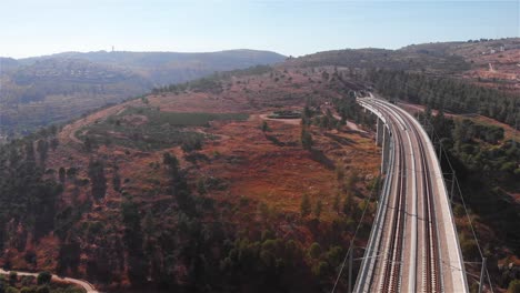 vista aérea de una línea ferroviaria de alta velocidad a través de un terreno montañoso