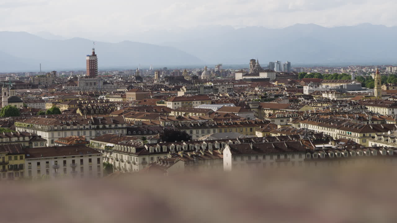 Dolly leggero sullo skyline di Torino con un primo piano sfocato in movimento.