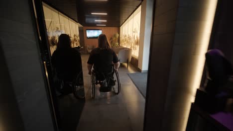 a woman in a wheelchair enters a stylish, dimly lit restaurant with modern decor and artistic elements. the scene highlights accessibility in a trendy dining environment, emphasizing mobility and inclusive design.