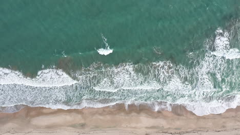 Kleine-Wellen-Brechen-Einen-Sandstrand,-Blaues-Wasser-In-Der-Nähe-Von-Montpellier.-Antenne