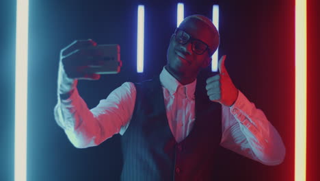 man taking a selfie in neon lights