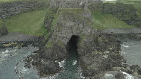 Cueva-De-La-Sirena-Debajo-Del-Castillo-De-Dunluce,-Condado-De-Antrim,-Irlanda-Del-Norte---Antena