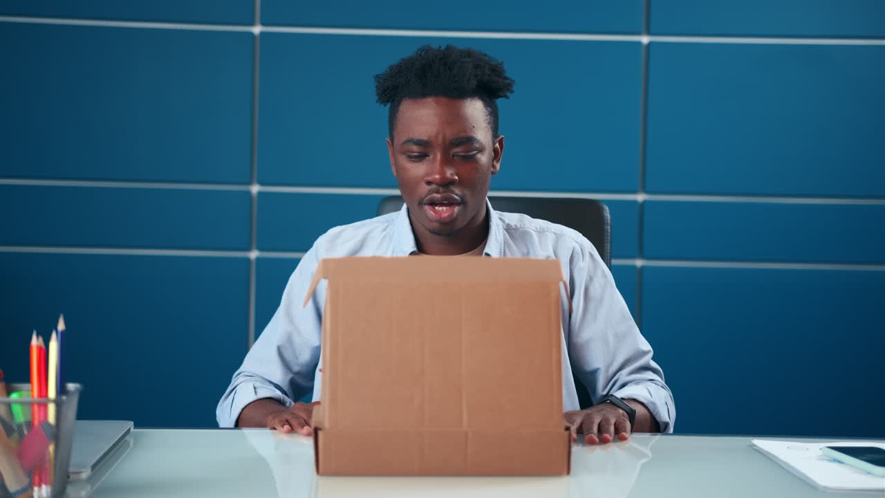 Frustrated african american man open cardboard box receive damaged wrong parcel