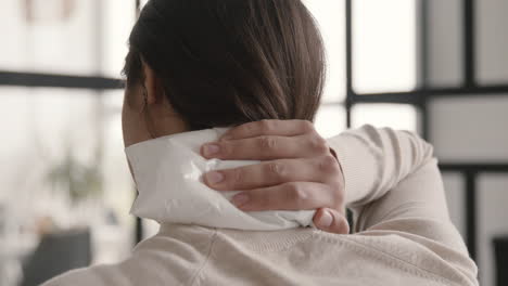 Back-View-Of-A-Suffering-Woman-Trying-To-Relieve-Neck-Pain-With-An-Ice-Pack-At-Home