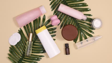 spa wellness skin care products with tropic palm leaves appear on beige background. stop motion flay lay