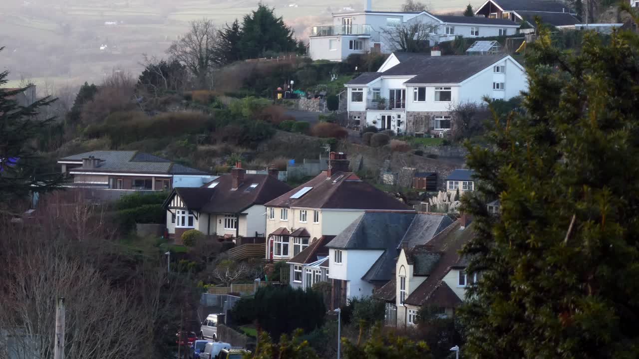 casas adosadas vista en la azotea a través de nebuloso paisaje del valle galés árbol soplando en el viento