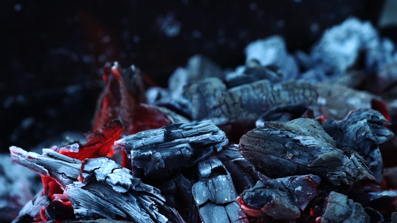 Wood and embers burning in orange flames. Bonfire. Slow motion