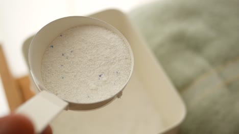 measuring laundry detergent with a scoop