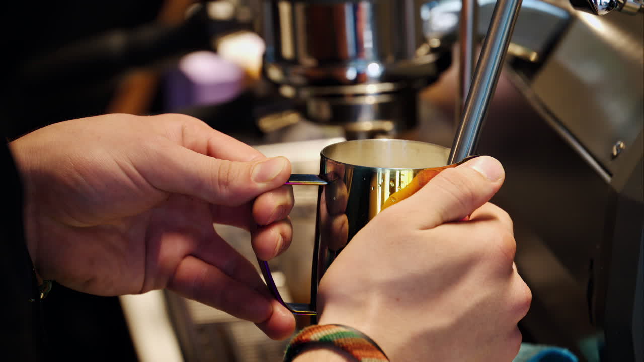 Close up of a woman pouring coffee in a cup from a glass pot standing on a wooden tray