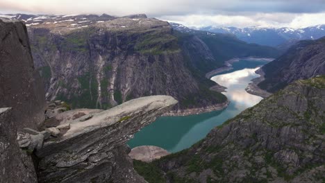 aerial boom shot above trolltunga overlooking norwegian mountains and lake ringedalsvatnet