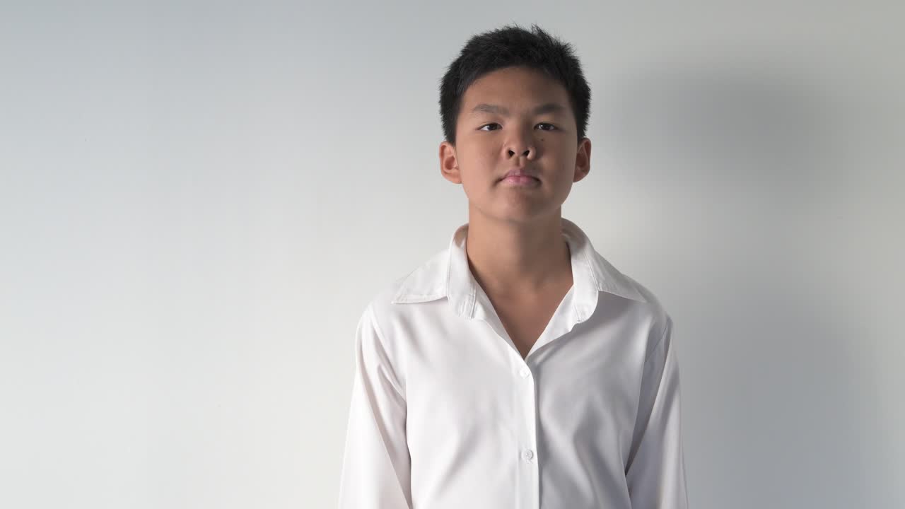 Portrait of happy Asian teenage boy smiling and making OK hand sign gesture