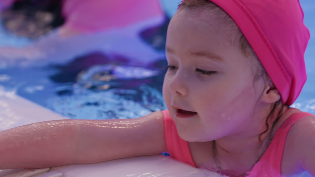 수영 수업 중 물가 근처 풀 포장 도로에 손을 짚고 몸을 지탱하는 아기, 젖은 타일이 빛나고, 지지, 자신감 형성, 슬래브 잡기, 물방울 튀김, 표면, 연습 지속