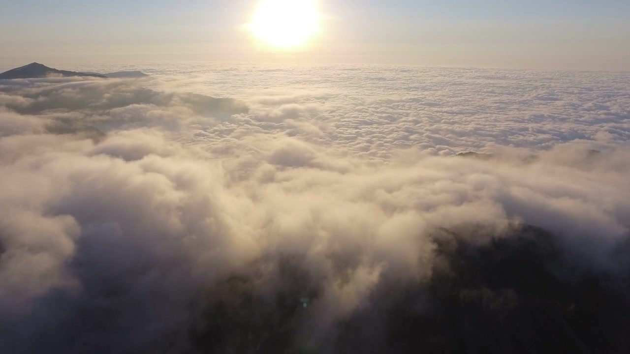 Vista aerea di cime montuose sopra un mare di nuvole al tramonto