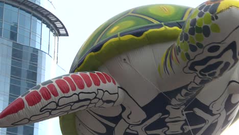 big turtle balloon diving on the sky during day of the dead parade in mexico city